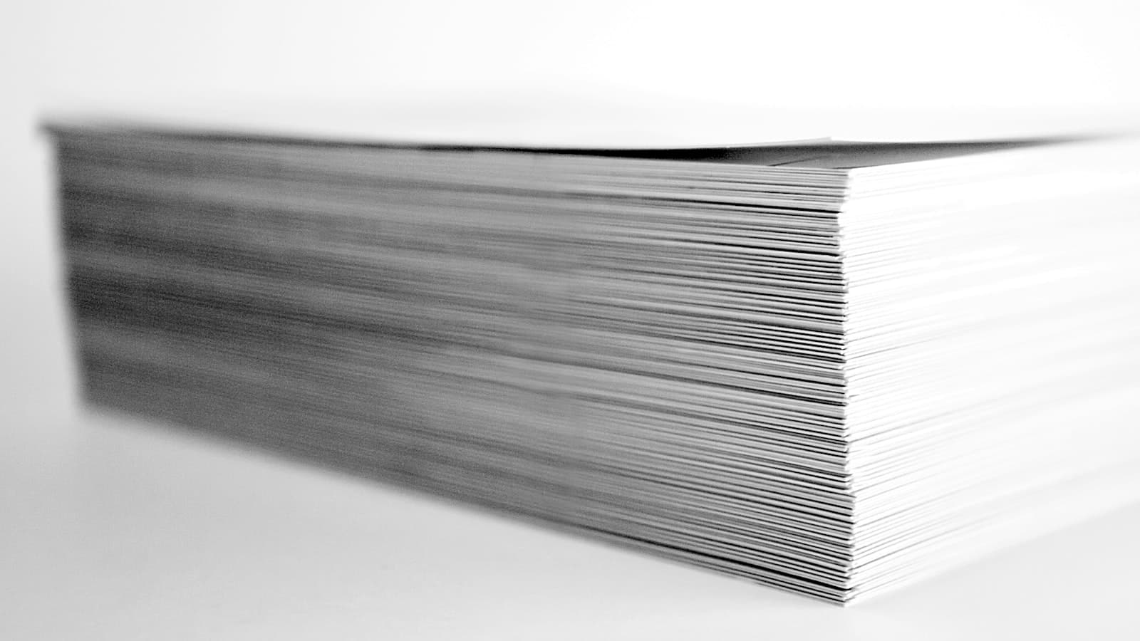 A close-up of a neat stack of white paper in black and white
