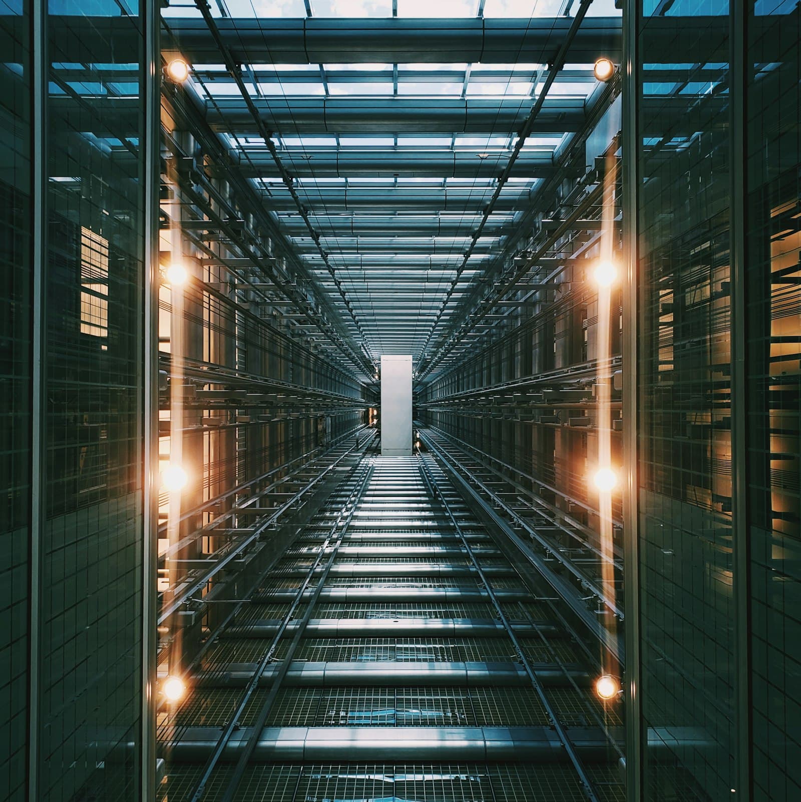A long symmetrical service corridor of repeating structural bays receding into the distance